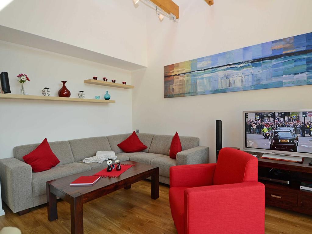 sala de estar con sofá y sillas rojas en Ferienhaus Luv & Lee - Apt. 01, en Ostseebad Sellin