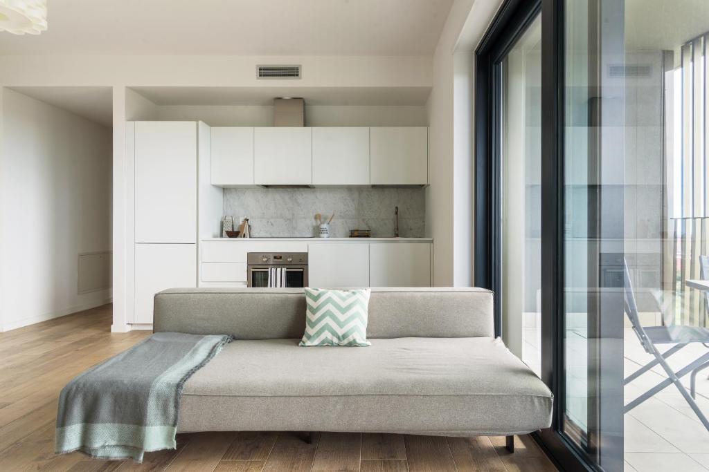un soggiorno con divano e una cucina di JOIVY UpTown Flats with Balcony, Good Connection to Milan Centre a Milano