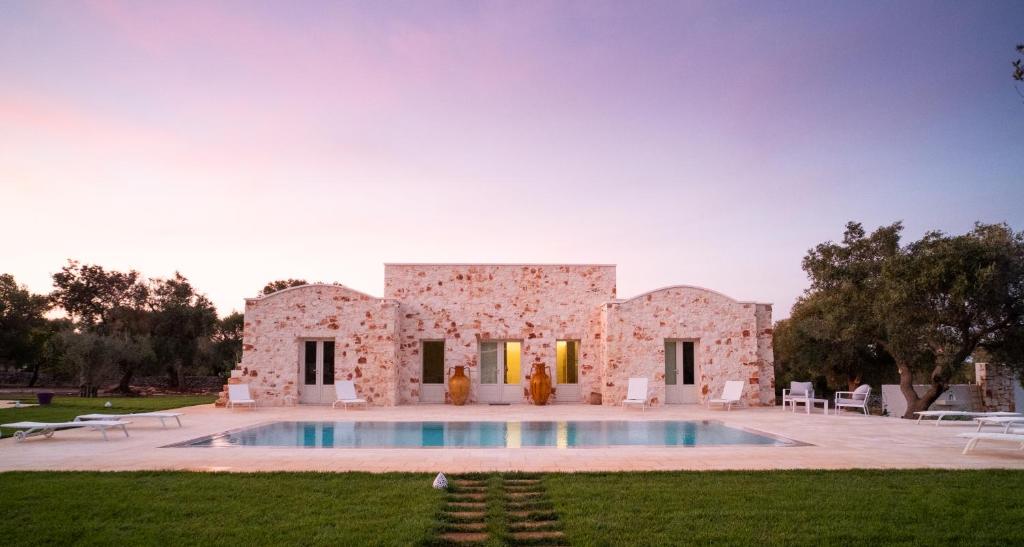 une maison en pierre avec une piscine en face de celle-ci dans l'établissement Casa Tonini, à Ostuni