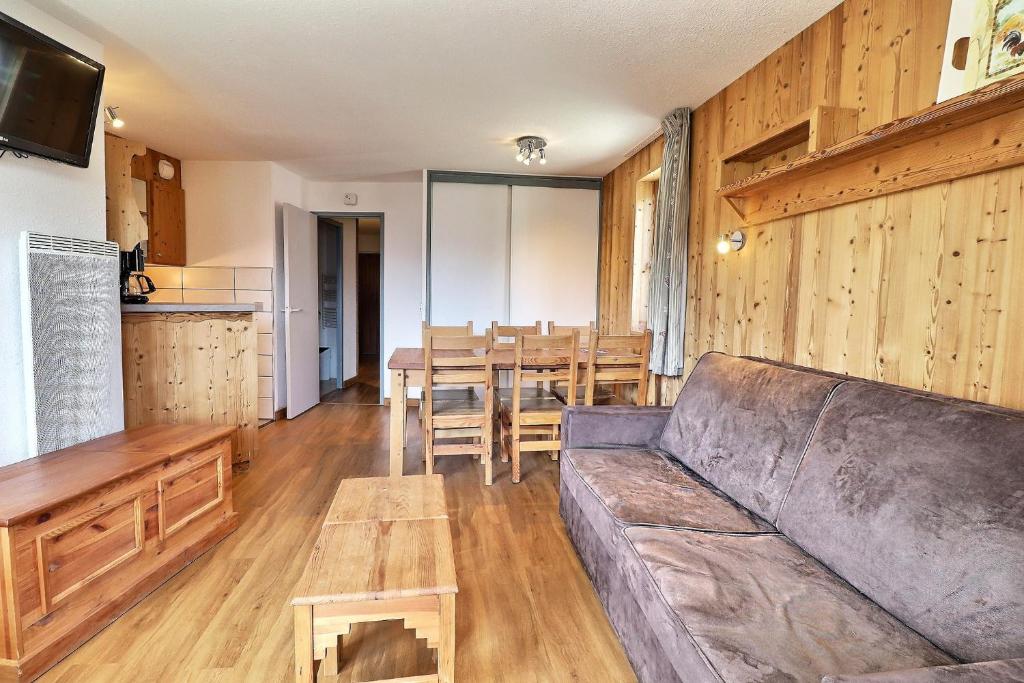 een woonkamer met een bank en een tafel bij Le Grand Bois in Courchevel