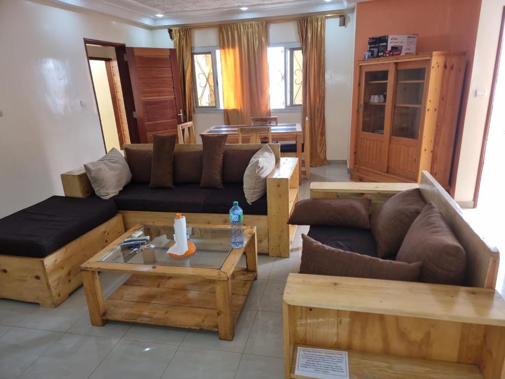 Sala de estar con sofás y mesa de centro en CHAMBRES PRIVEES CLIMATISEES-DOUCHES PERSONNELLES-NEFLIX-SALON, en Dakar