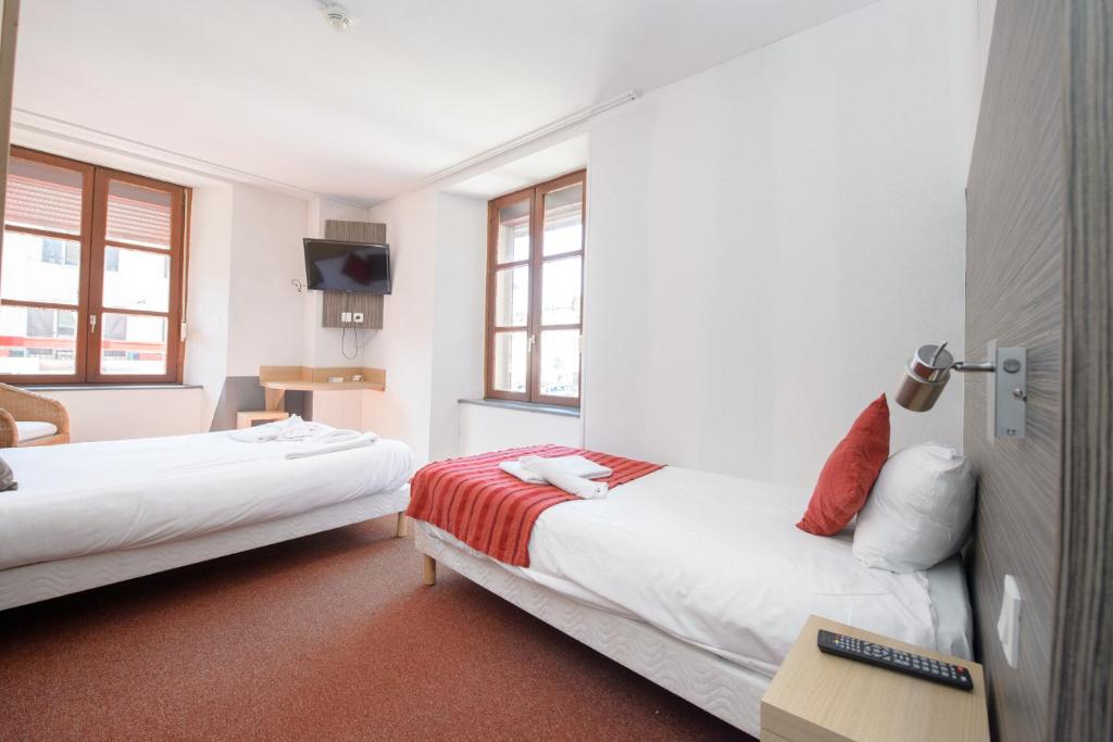 um quarto de hotel com duas camas e uma televisão em HOTEL DES VOYAGEURS em Pont-de-Roide