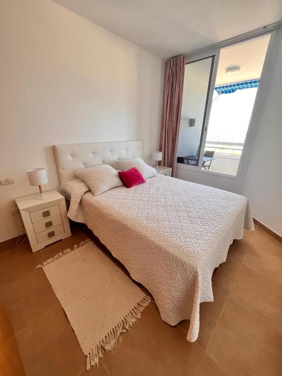 a bedroom with a large bed and a window at Precioso apartamento en 5 minutos de la playa in Playa de las Americas