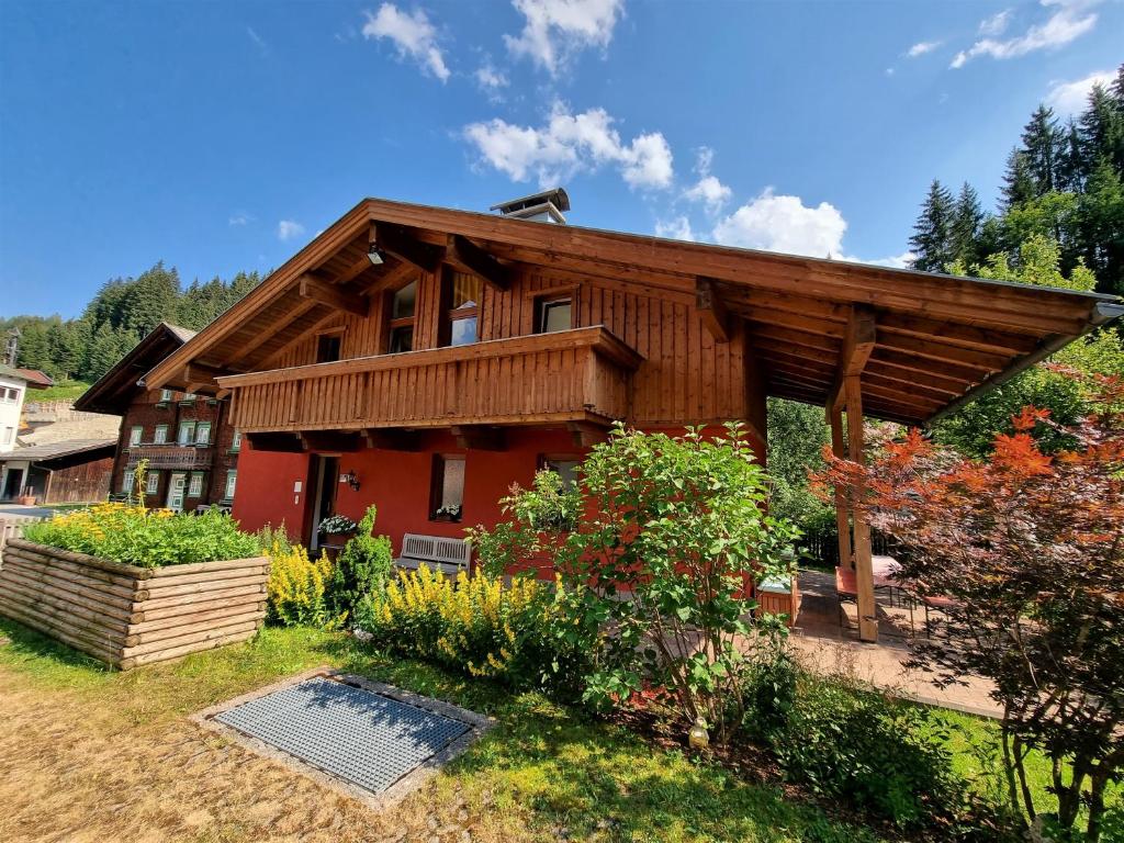 ein Haus mit einem Holzhaus mit einem Garten in der Unterkunft Ferienhaus Berghof in Gerlos