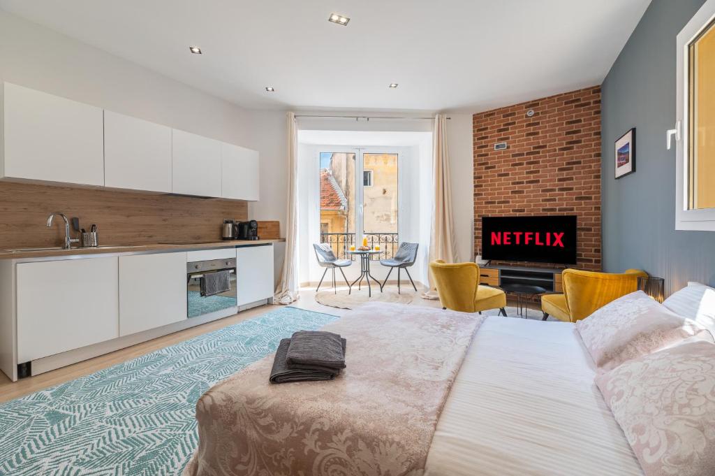 Cet appartement comprend une chambre avec un lit, une cuisine et un salon. dans l'établissement SPACIEUX STUDIO HAUT PLAFOND PROCHE MONACO, à Beausoleil