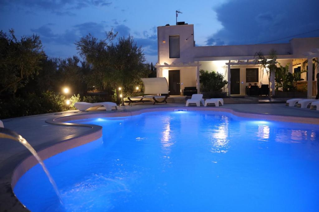 una piscina di fronte a una casa di notte di Relais Belvedere a Giovinazzo