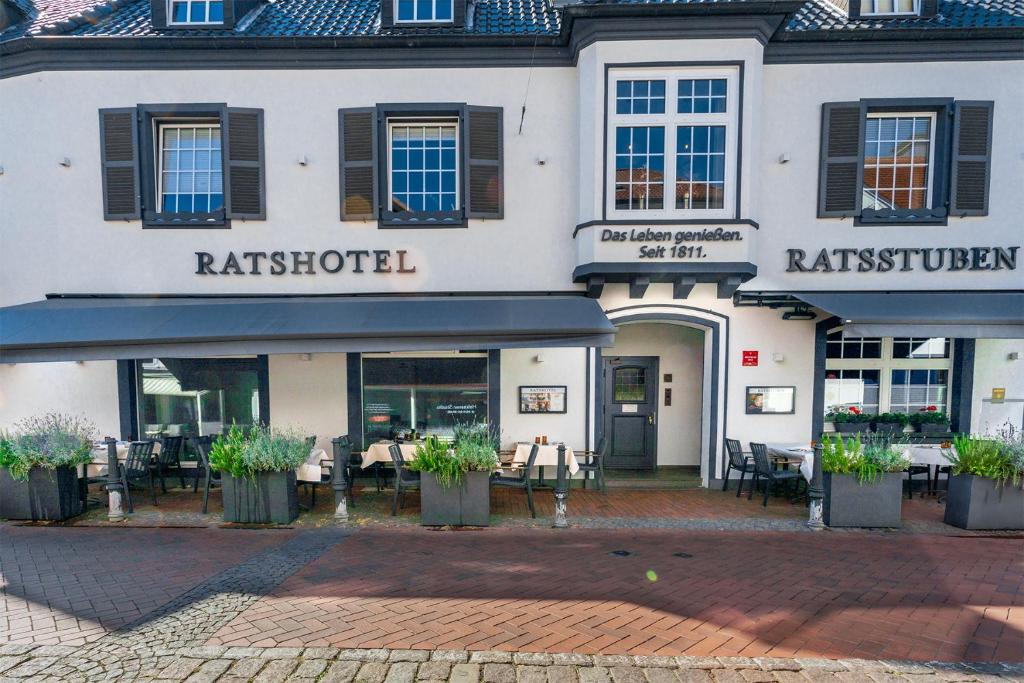 a hotel with tables and chairs in front of it at Ratshotel in Haltern