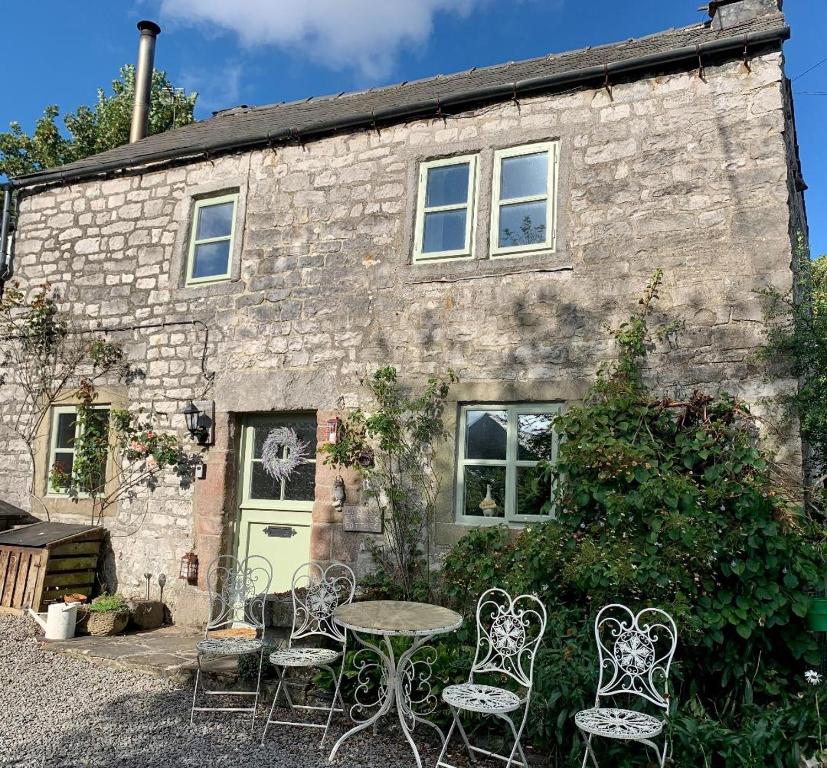 a table and chairs in front of a stone house at Crosse Chance Cottage - Idyllic, beautiful, traditional cottage to love - Wood burner in Taddington