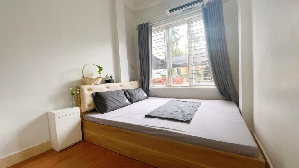 a bed in a small room with a window at Cuccu homestay in Kiến An