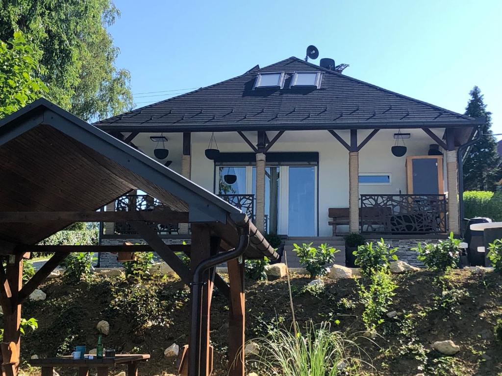 uma pequena casa com um gazebo num quintal em Tó Kincse Vendégház em Kustánszeg