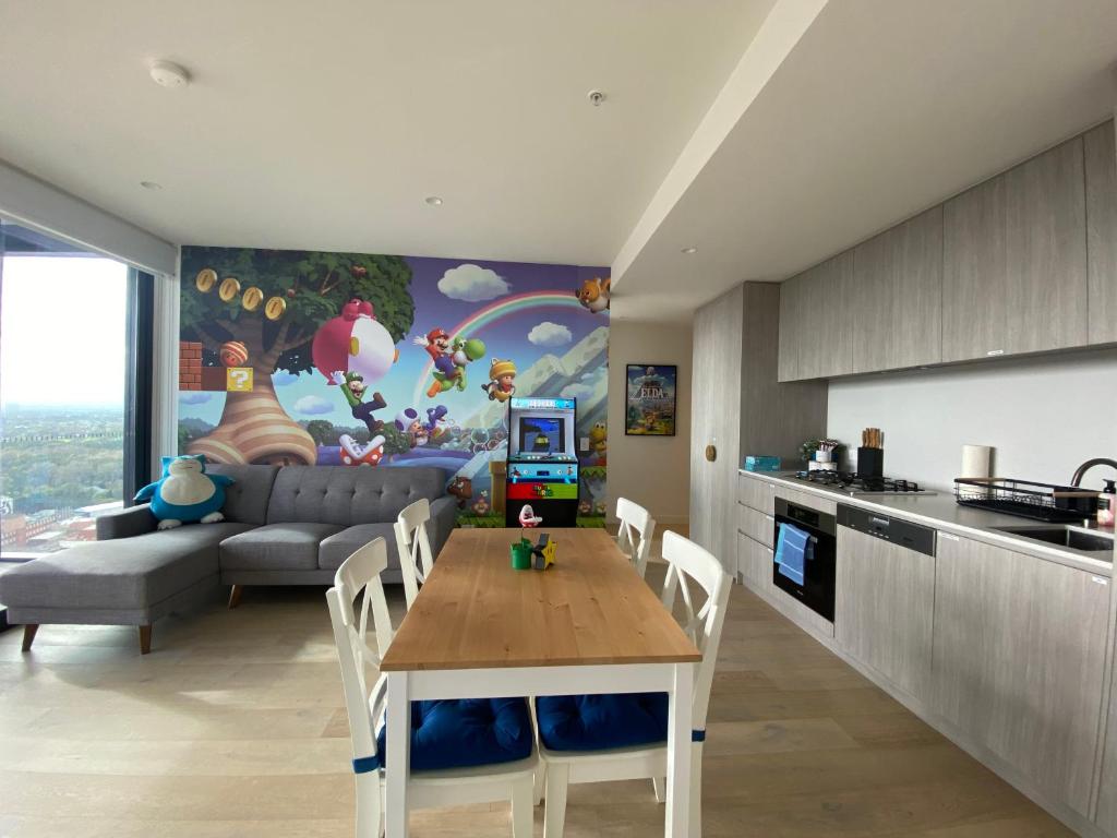 a kitchen and living room with a table and a couch at Nintendo Theme-Adelaide CBD-King Bed-Spa-Gym-BBQ in Adelaide