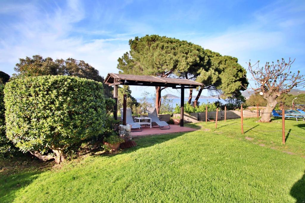 een tuinhuisje in een tuin met een groen gazon bij Casa del Mare - Oasi verde a soli 100m dal mare! in Marciana Marina