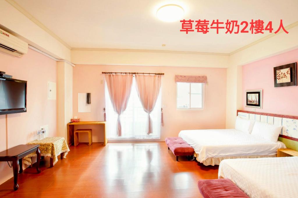 a bedroom with a bed and a tv and a window at 草莓牛奶台東民宿可洽包棟 in Taitung City