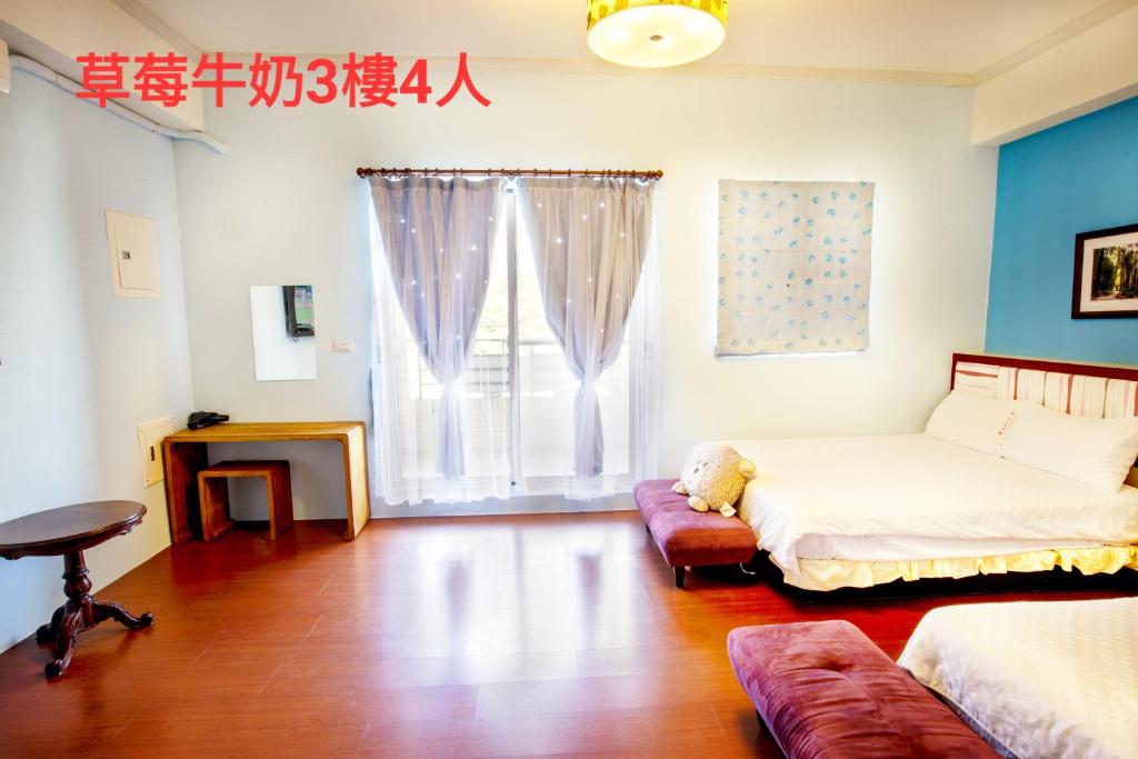 a bedroom with a bed and a couch and a window at 草莓牛奶台東民宿可洽包棟 in Taitung City