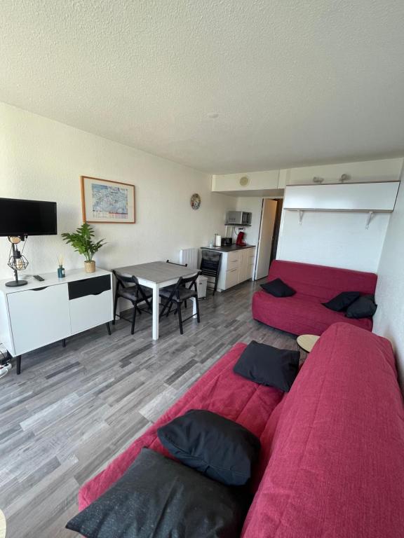 een woonkamer met 2 bedden en een tafel bij Studio au pied des pistes 4 pers, Alpes Le Corbier in Le Corbier