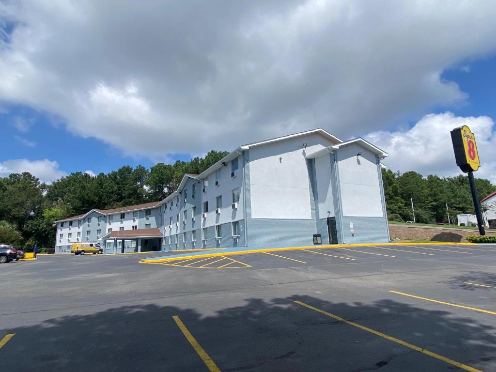 a building in a parking lot next to a parking lot at Super 8 by Wyndham Homewood Birmingham Area in Birmingham