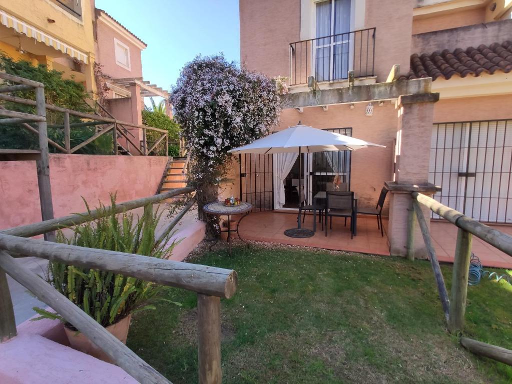 a patio with a table and an umbrella at Beach-Golf House in Islantilla