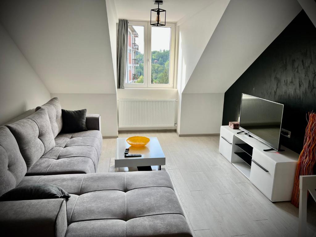 a living room with a couch and a tv at Lux Apartman Rudnik in Rudnik