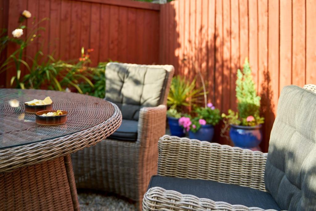 a patio with a table and chairs and a fence at Bossell Cottage Devon in Buckfastleigh