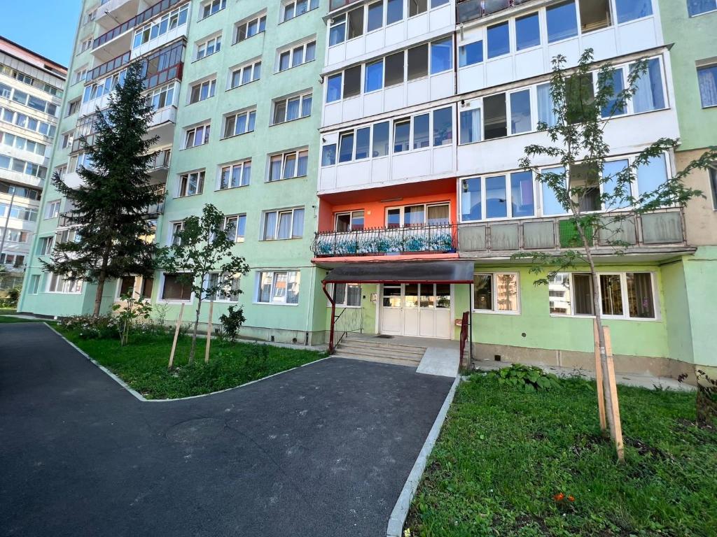 een appartementencomplex met een parkeerplaats ervoor bij Muntean Residence in Sibiu