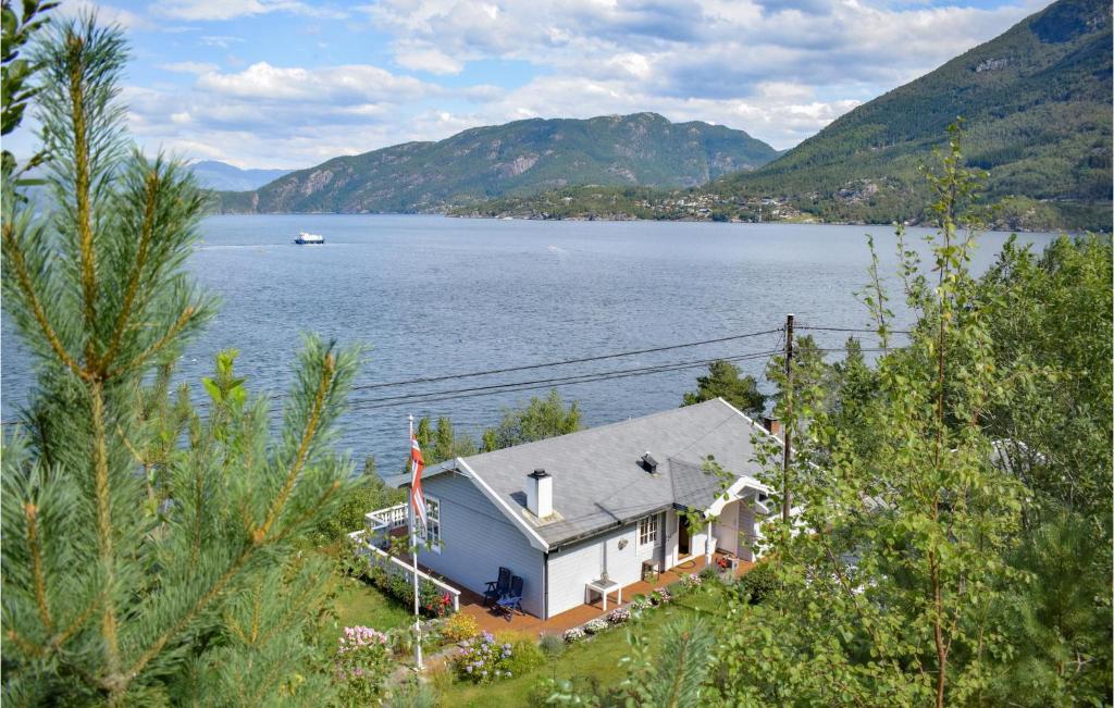 a house on the shore of a large body of water at Beach Front Home In Jondal With House Sea View in Jondal