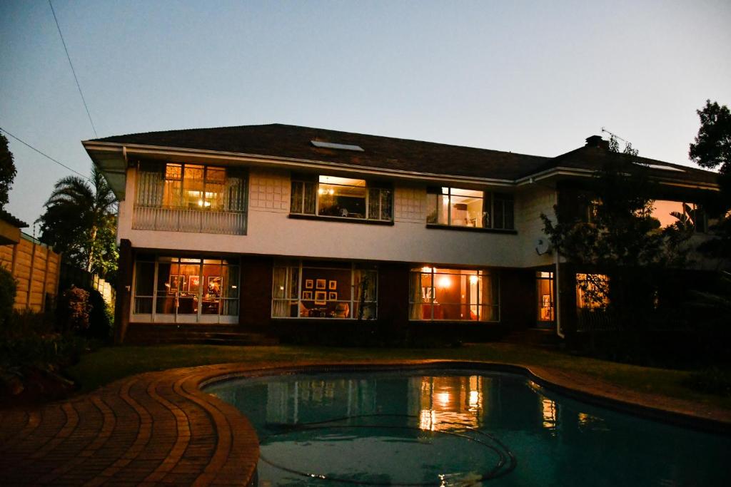 una casa con piscina frente a ella en THE WHITE HOUSE, en Johannesburgo