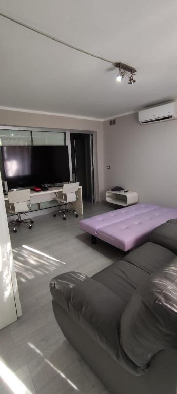 カストロ・ディ・レッチェにあるBilocale vicino al centro storicoの紫色のマットレスと薄型テレビが備わる客室です。