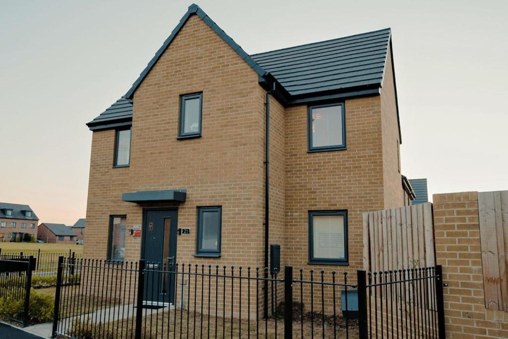a brown brick house with a black roof at Willow Heights Modern 5-7 Persons/3 Bed Detached in Rotherham