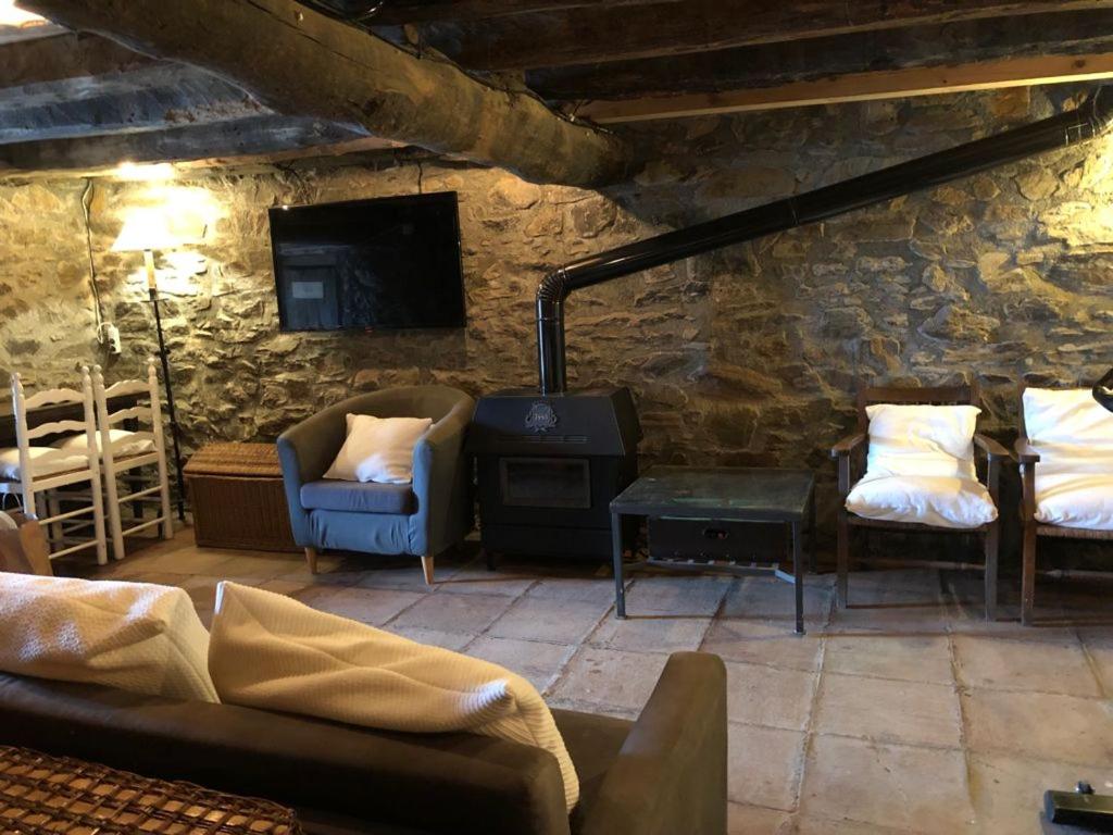 uma sala de estar com sofás e uma parede de pedra em Charming Stone House in the Pre-Pyrennes em Ribes de Freser