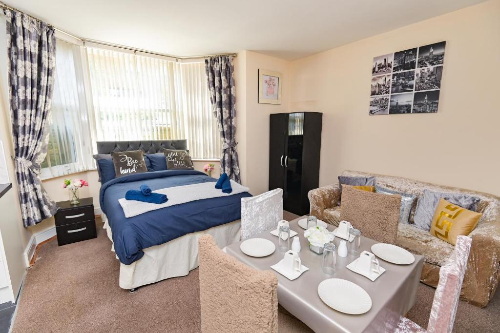 a bedroom with a bed and a table and a couch at The Elm Wood Apartments in Huddersfield