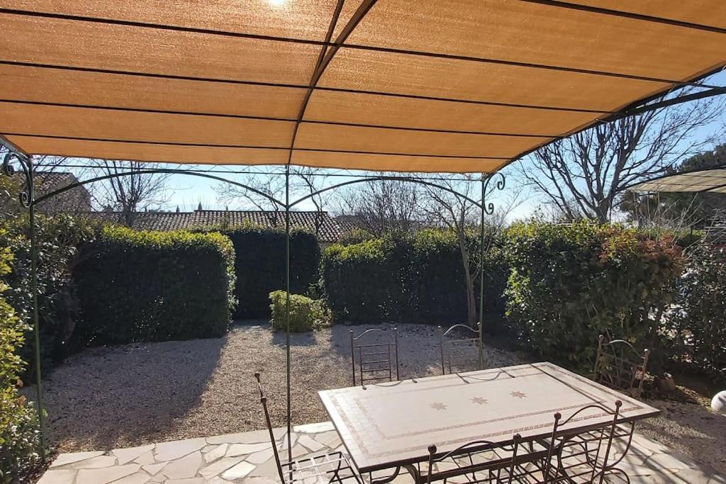 - une table de pique-nique sous un grand parasol en bois dans l'établissement Bastidon Plein Sud, à Gordes