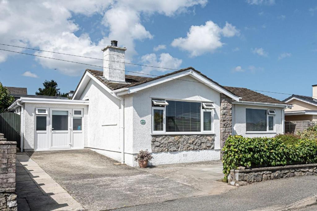 uma casa branca com uma chaminé por cima. em Lon Penrhyn em Benllech