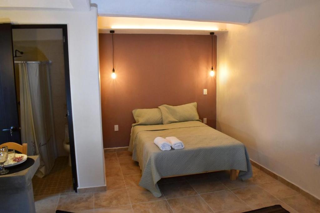 a bedroom with a bed with two towels on it at Casa Monarca in Oaxaca City