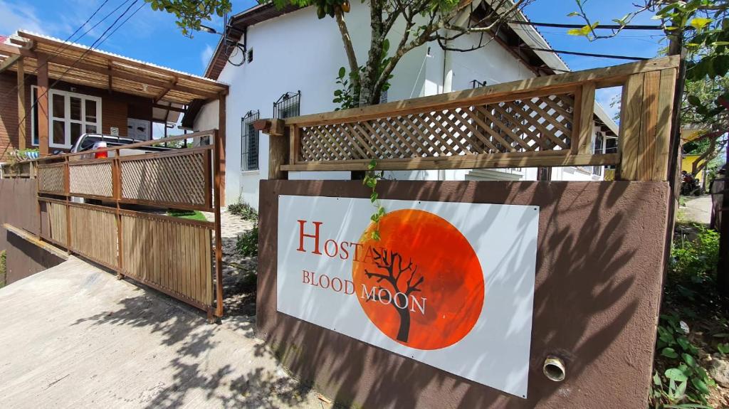 een bord aan de zijkant van een huis bij Hostal Blood Moon in Rio Dulce