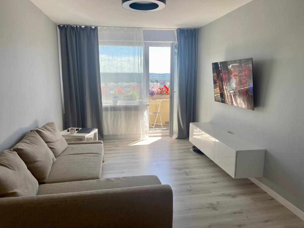 panoramic view and free parking في فيلنيوس: غرفة معيشة مع أريكة ونافذة كبيرة