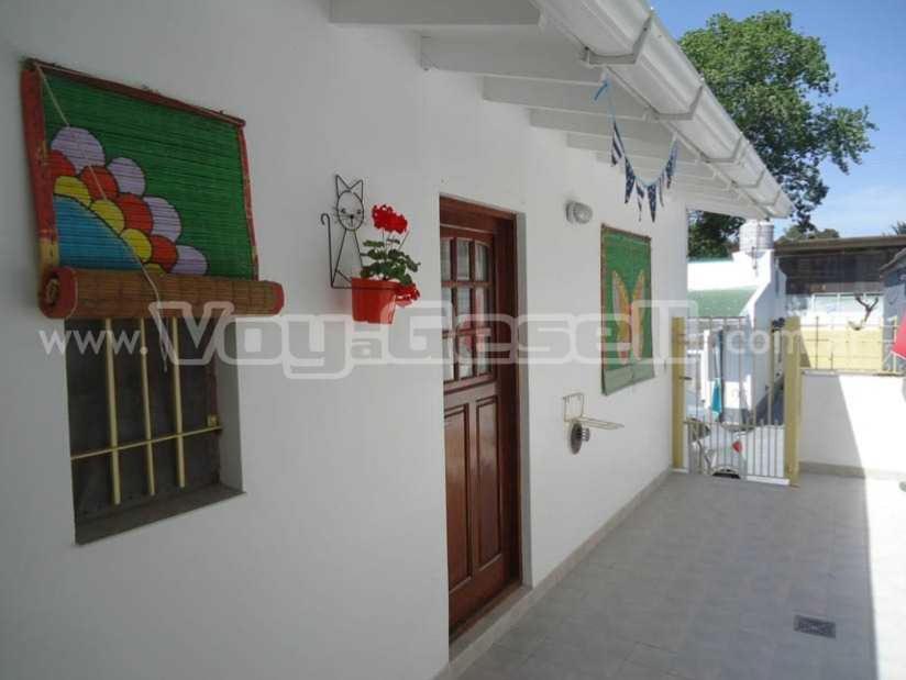 una casa blanca con una puerta y un balcón en el Relax Maya en Villa Gesell