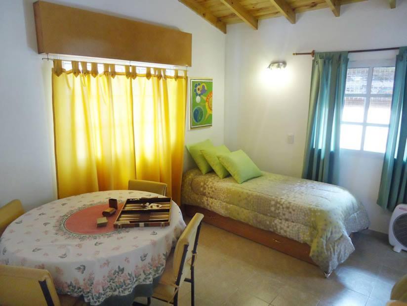 1 dormitorio con 1 cama, mesa y sillas en Relax Maya en Villa Gesell