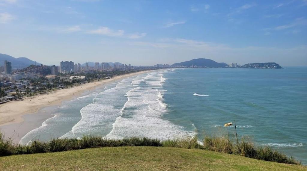 widok na plażę z miastem w tle w obiekcie Apartamentos Enseada Guaruja w mieście Guarujá
