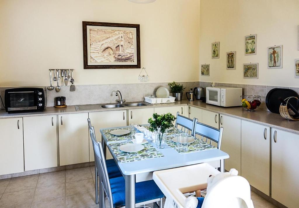 a kitchen with a table with chairs and a microwave at Elafonisi Vacation Blue Apartment in Agios Padeleimon