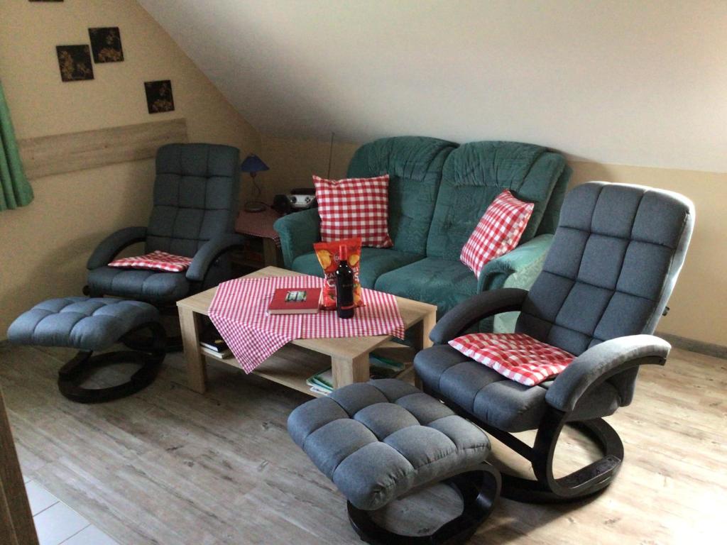 a living room with three chairs and a table at Nordseekrabbe Bollmann in Carolinensiel