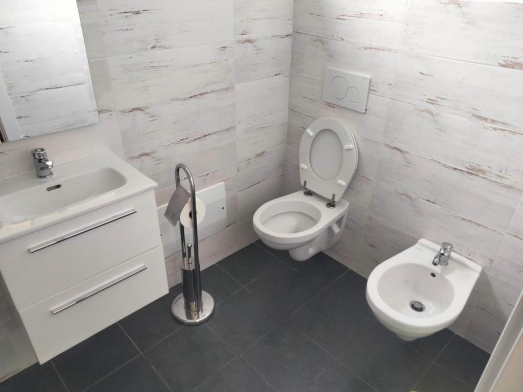 a white bathroom with a toilet and a sink at La casa di Nathan vicino baia blu in Lerici