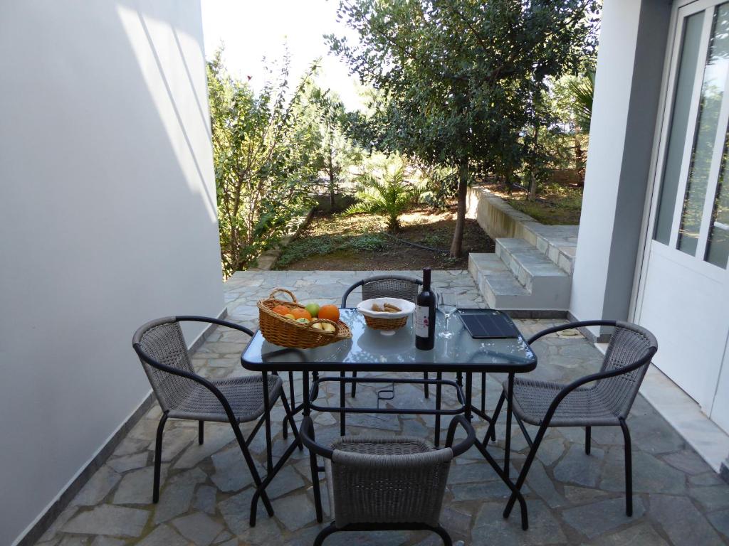 a table with chairs and a bowl of fruit on a patio at Elafonisi Vacation Green Studio in Agios Padeleimon