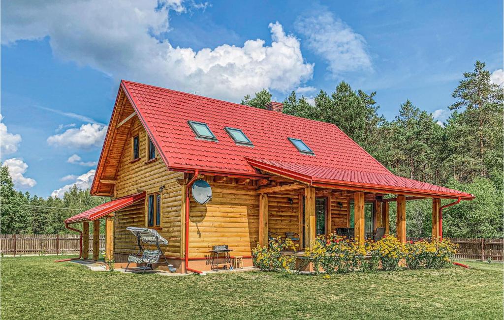 a log cabin with a red roof at 4 Bedroom Amazing Home In Ruciane-nida in Karwica