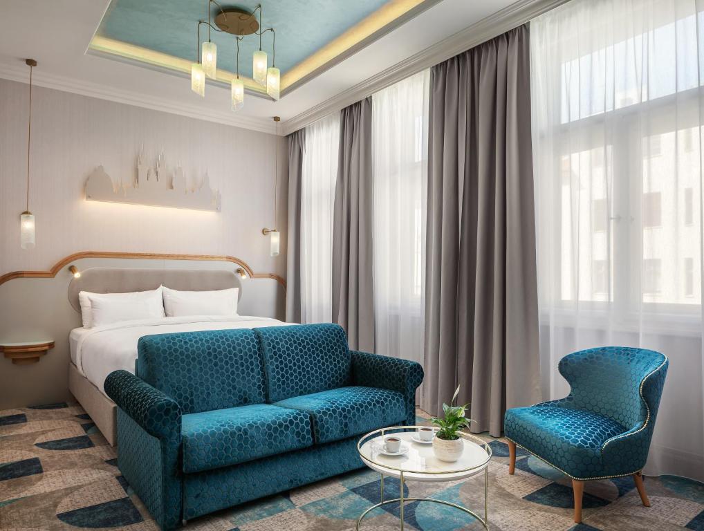 una camera d'albergo con letto e sedia blu di Allure Hotel Prague a Praga