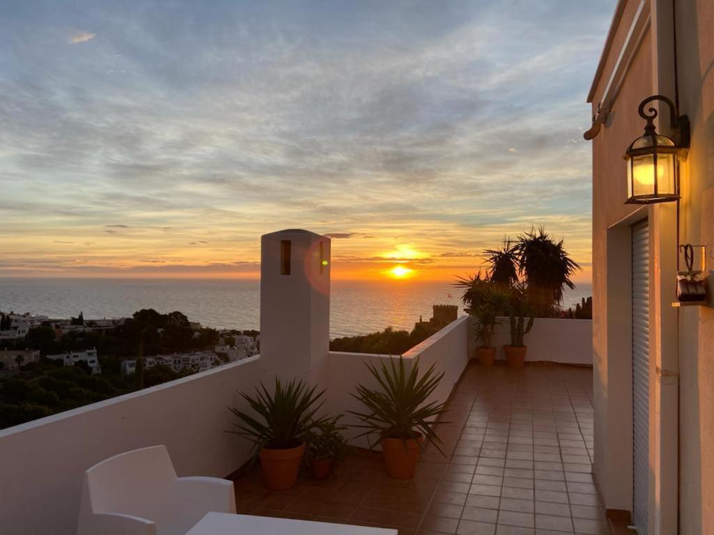 a balcony with a view of the ocean at sunset at AMR Ático Los Atalayones in Mojácar