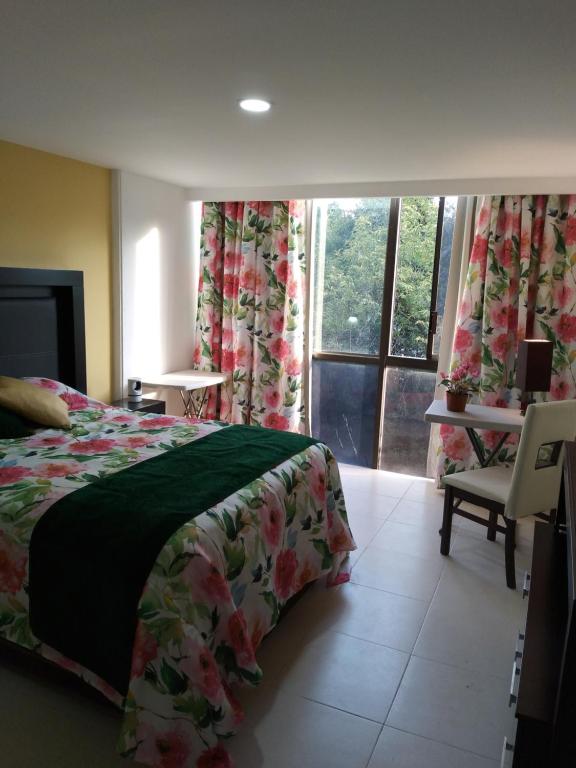 een slaapkamer met een bed, een raam en een stoel bij Charming sunny bedroom overlooking beautiful Amsterdam Avenue in best Condesa area in Mexico-Stad