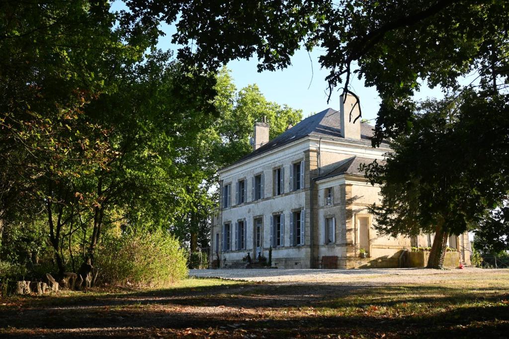 uma grande casa branca com árvores em frente em Chateau Morinerie 
