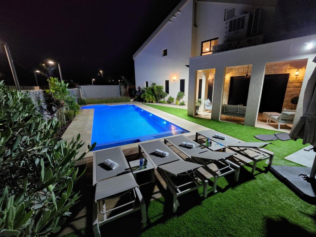 einen Hinterhof mit Pool in der Nacht in der Unterkunft סוויטות נוף לתבור in Giv'at Avni