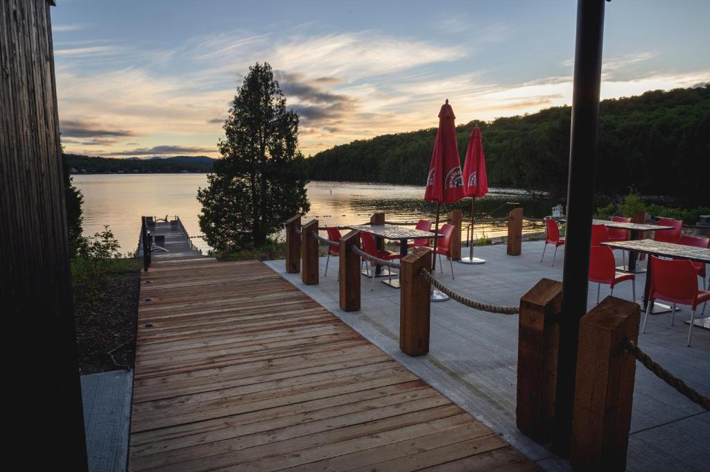a wooden dock with tables and chairs on a lake at Station Touristique Duchesnay - Sepaq in Sainte-Catherine