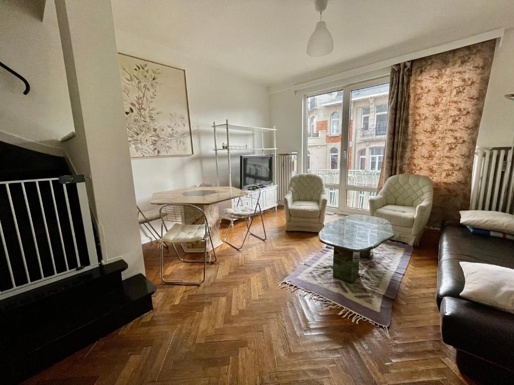 ein Wohnzimmer mit einem Sofa und einem Tisch in der Unterkunft Superbe appartement DUPLEX avec Jacuzzi in Brüssel